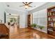 Bedroom featuring light hardwood floors, built-in bookcase, and an open doorway to another room with rocking chairs at 601 Laurel Xing, Canton, GA 30114