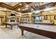 Billiard room with stone fireplace, TV, recessed lighting, coffered ceilings and three tables at 601 Laurel Xing, Canton, GA 30114