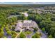 An aerial view highlights a grand clubhouse with a pool, lush greenery, and surrounding residences by a lake at 601 Laurel Xing, Canton, GA 30114