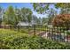 A fenced community garden with a greenhouse, raised beds and an iron garden bench at 601 Laurel Xing, Canton, GA 30114