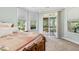 Spacious primary bedroom features carpet floors, an exit to a screened in porch and large windows overlooking lush greenery at 601 Laurel Xing, Canton, GA 30114