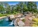 The community entrance featuring a water feature with lush landscaping and a waterfall at 601 Laurel Xing, Canton, GA 30114
