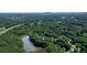 Aerial view highlighting the wooded community, lake, and proximity to nearby amenities at 109 Lake Latimer Ne Cv, Kennesaw, GA 30144