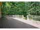 Large wooden deck with white railings overlooking a wooded yard with lush trees at 109 Lake Latimer Ne Cv, Kennesaw, GA 30144
