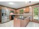 Kitchen features stainless steel appliances, a center island with stone counters and a view of the yard at 109 Lake Latimer Ne Cv, Kennesaw, GA 30144