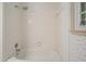 Bathroom shower area featuring white tiled walls, shower head, and window at 109 Lake Latimer Ne Cv, Kennesaw, GA 30144
