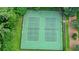 An aerial view of well-maintained green tennis courts surrounded by landscaped grounds at 109 Lake Latimer Ne Cv, Kennesaw, GA 30144