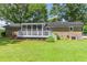 Back of the home with a screened in porch and a large yard at 3152 H D Atha Rd, Covington, GA 30014