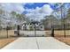 View of a stately two-story home through a black iron security gate and concrete driveway at 4090 Sandy Lake Dr, Lithonia, GA 30038