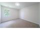This bedroom features neutral carpet, trim, and one large window for an inviting and bright look at 5916 Farmbrook Ln, Rex, GA 30273