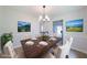 Dining room with wood table, upholstered chairs, decorative chandelier, and scenic wall art at 5916 Farmbrook Ln, Rex, GA 30273