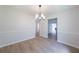 Dining room with modern chandelier and wood-look flooring at 5916 Farmbrook Ln, Rex, GA 30273