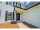 Inviting entrance with a modern black door and traditional white siding at 5916 Farmbrook Ln, Rex, GA 30273