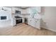 Modern kitchen with stainless steel appliances, white cabinets, and a view into the living room at 5916 Farmbrook Ln, Rex, GA 30273