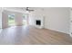 Bright living room with modern wood-look flooring, fireplace, ceiling fan, and natural light from large windows at 5916 Farmbrook Ln, Rex, GA 30273