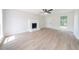 Bright living room features wood-look flooring, fireplace, ceiling fan, and white door at 5916 Farmbrook Ln, Rex, GA 30273