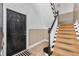 Inviting entryway featuring staircase with black railing, neutral walls, tiled floor, and front door at 872 Briarcliff Ne Rd # B2, Atlanta, GA 30306