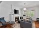 Cozy living room features a fireplace, large windows, hardwood floors and a modern chandelier at 872 Briarcliff Ne Rd # B2, Atlanta, GA 30306