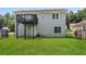 Home's backyard featuring lush green grass, a black fence, and a wooden deck on the upper level at 113 Garden Walk, Stockbridge, GA 30281
