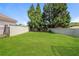 View of the backyard showcasing a well-maintained lawn and a concrete retaining wall for privacy at 113 Garden Walk, Stockbridge, GA 30281