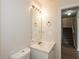 Cozy bathroom featuring a single sink vanity, a well-lit mirror, and a glimpse of the staircase at 113 Garden Walk, Stockbridge, GA 30281