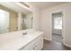 Bathroom featuring a white vanity, a large mirror and wood-look vinyl flooring at 113 Garden Walk, Stockbridge, GA 30281