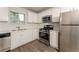 Modern kitchen featuring white cabinets, stainless steel appliances, and a view to the backyard at 113 Garden Walk, Stockbridge, GA 30281