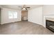 Inviting living room featuring a fireplace, modern ceiling fan, and light wood grain floors at 113 Garden Walk, Stockbridge, GA 30281