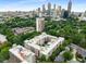 Aerial view showcases the building's courtyard pool and lush surroundings, with the city skyline beyond at 384 Ralph Mcgill Ne Blvd # 123, Atlanta, GA 30312