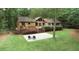 Expansive backyard with mature trees, deck, and stone patio seating area, perfect for outdoor entertaining at 3852 Vinyard Ne Ct, Marietta, GA 30062