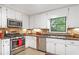 Well-lit kitchen with stainless steel appliances, white cabinets, and tile backsplash at 3852 Vinyard Ne Ct, Marietta, GA 30062