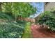 Green backyard view showcasing a lush hillside covered in ground cover, as well as a view of the fence and part of the house at 4477 Village Dr, Atlanta, GA 30338