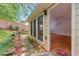 Backyard featuring a stone pathway, lush green grass, and the side of the house with windows and access to the interior at 4477 Village Dr, Atlanta, GA 30338