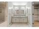 Bright bathroom with a double sink vanity, shower, and adjacent walk-in closet at 4477 Village Dr, Atlanta, GA 30338