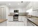 Bright kitchen featuring white cabinets, stainless steel appliances, and granite countertops at 4477 Village Dr, Atlanta, GA 30338