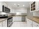 Well-lit kitchen with stainless steel appliances, granite countertops, and white cabinetry at 4477 Village Dr, Atlanta, GA 30338