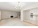 Spacious living room featuring a fireplace, chandelier, and view of the kitchen with stainless steel appliances at 4477 Village Dr, Atlanta, GA 30338