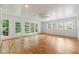 Bright sunroom boasts multiple windows, hardwood floors, and a white ceiling with fan and access to the backyard at 4477 Village Dr, Atlanta, GA 30338
