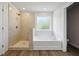 Bright bathroom featuring a soaking tub, a tiled walk-in shower and wood-look flooring at 193 Soseby Lake Ln, Grayson, GA 30017