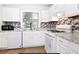 Modern kitchen with white cabinetry, tile backsplash, and updated appliances at 306 Autumn Leaf Way, Norcross, GA 30093