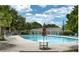 Community pool area showcasing a large pool with lounge chairs and umbrellas, surrounded by mature trees at 306 Autumn Leaf Way, Norcross, GA 30093