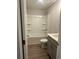 Bathroom with white tub and shower combo with white countertops and grey cabinets at 3579 Silvery Way, Powder Springs, GA 30127