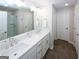 Bathroom featuring double sinks, white cabinets, tile floors, and a glass enclosed shower at 3579 Silvery Way, Powder Springs, GA 30127