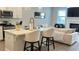 Bright kitchen overlooking the living room featuring white cabinetry, stone countertops, and modern stainless appliances at 3579 Silvery Way, Powder Springs, GA 30127