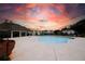 Community pool with bath house set against a colorful sunset sky and surrounding neighborhood homes at 3579 Silvery Way, Powder Springs, GA 30127