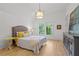 Bright bedroom with light wood floors, white walls, and a cozy bed with yellow decorative pillows at 1433 Wessyngton Ne Rd, Atlanta, GA 30306