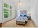 Sunlit bedroom with a large window, hardwood floors, and a comfortable bed with a decorative bench at 1433 Wessyngton Ne Rd, Atlanta, GA 30306