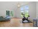 Sunlit bonus room with a Peloton bike, lounge chair, and large windows overlooking trees at 1433 Wessyngton Ne Rd, Atlanta, GA 30306
