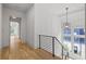 Bright hallway with hardwood floors, black railing, large window, and modern chandelier at 1433 Wessyngton Ne Rd, Atlanta, GA 30306