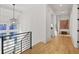 Hallway with hardwood floors, modern lighting, and staircase with black metal railing at 1433 Wessyngton Ne Rd, Atlanta, GA 30306